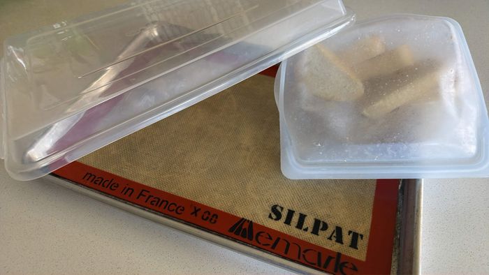 The sheet pan, Silpat, a Stasher bag with bread slices, and the miracle cover all together